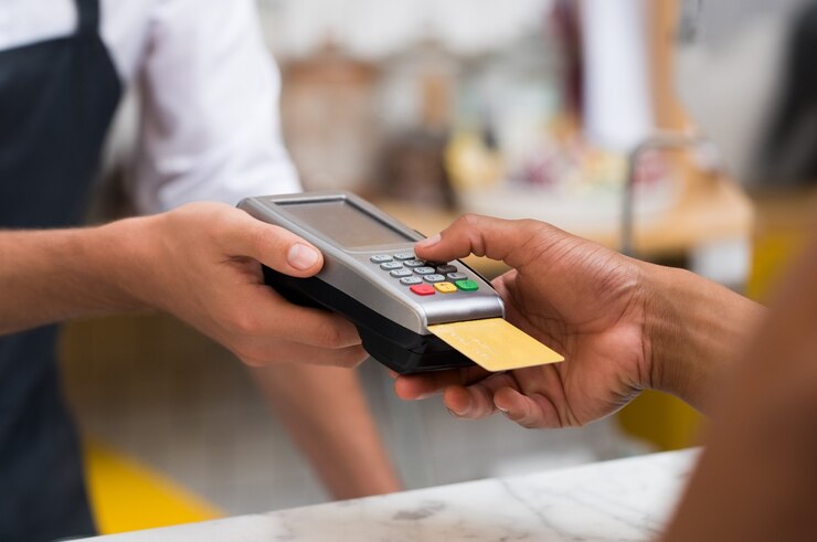 close-up-hand-using-credit-card-swiping-machine-pay_256588-1989